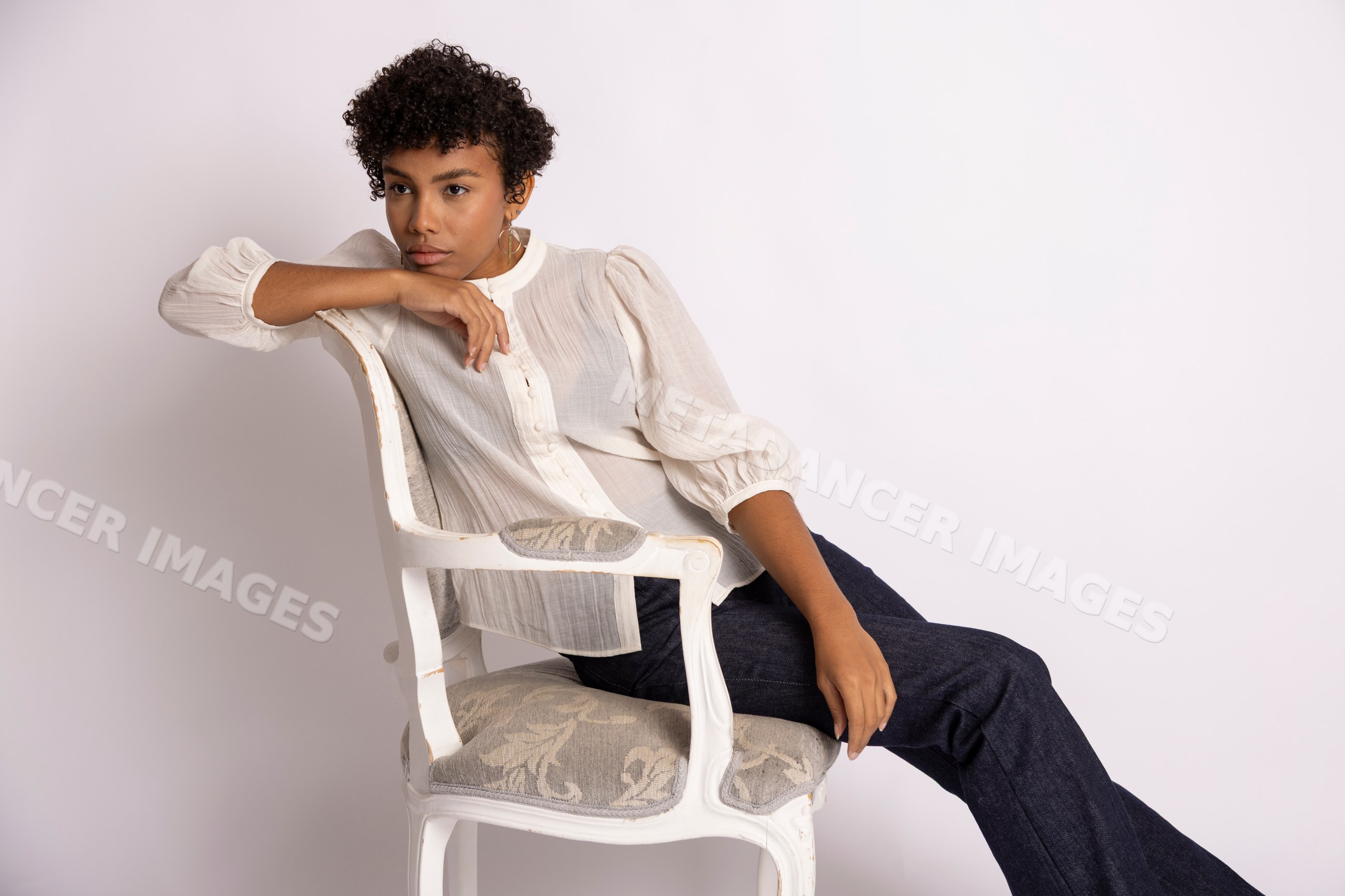 Hispanic woman seated on vintage armchair