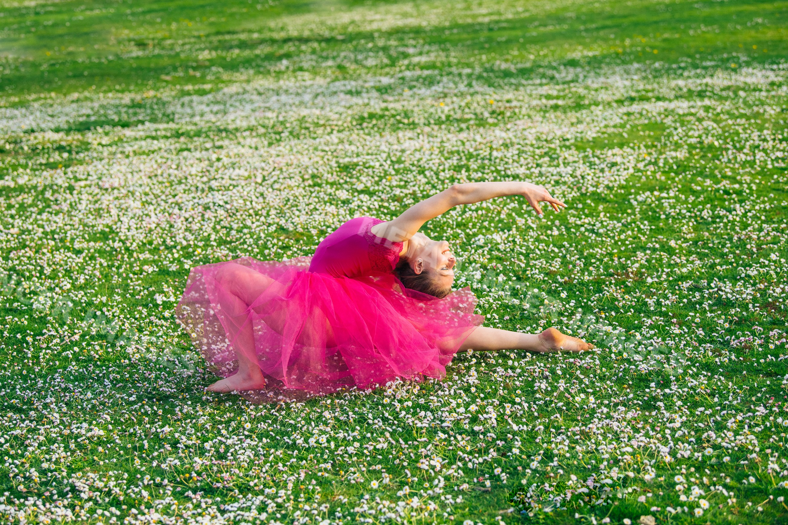 Ballet white dancer in pink tutu performing graceful pose outdoors