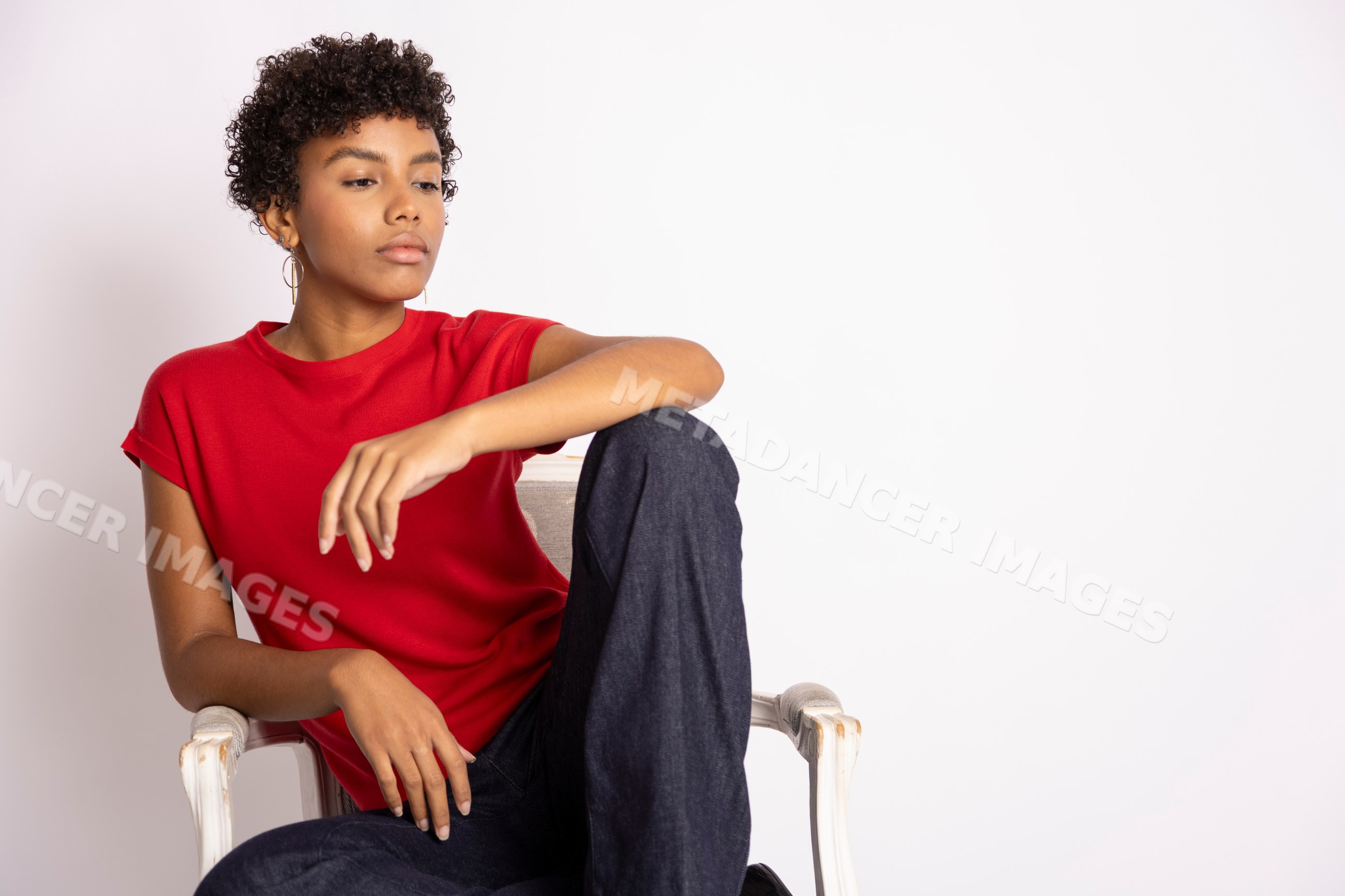 Hispanic woman sitting thoughtfully wearing red shirt