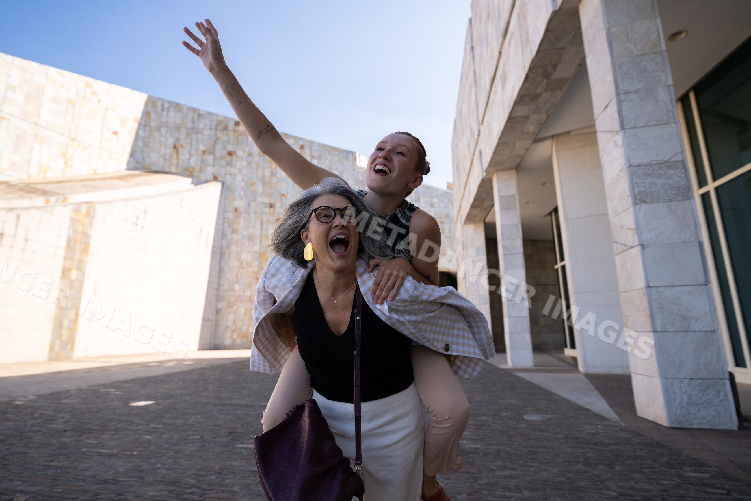 White women sharing joyful piggyback moment outdoors