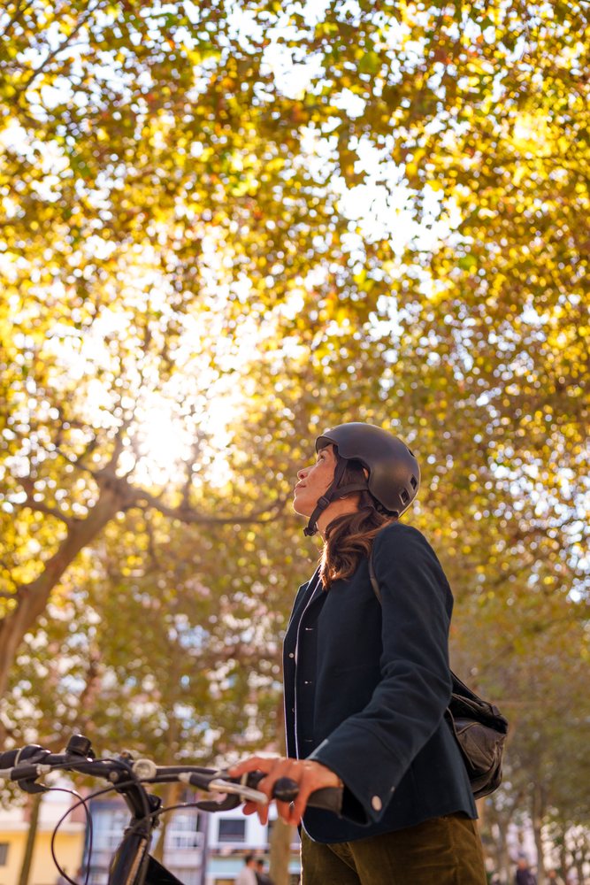 Hispanic woman holding bicycle handlebars looking