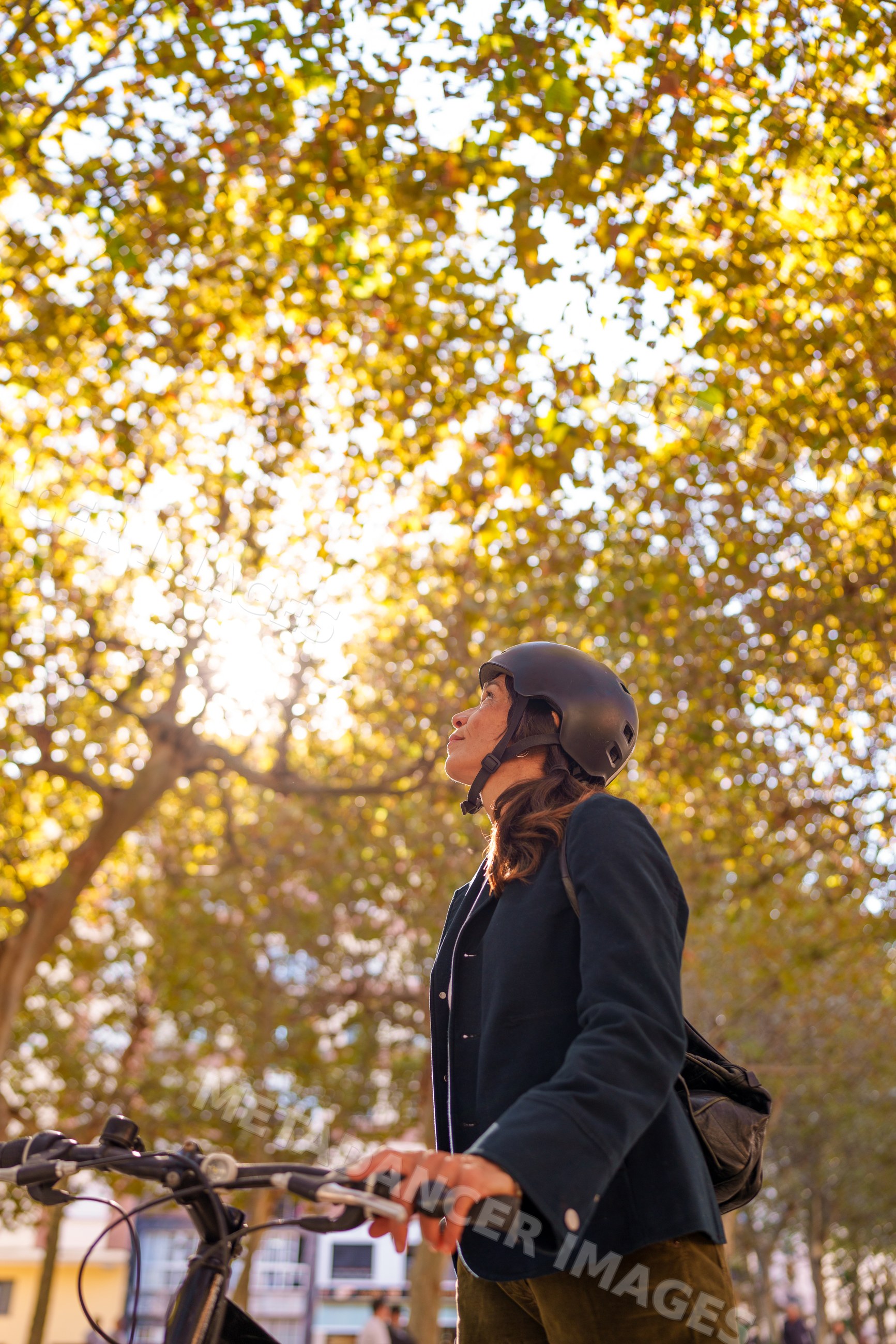 Hispanic woman holding bicycle handlebars looking