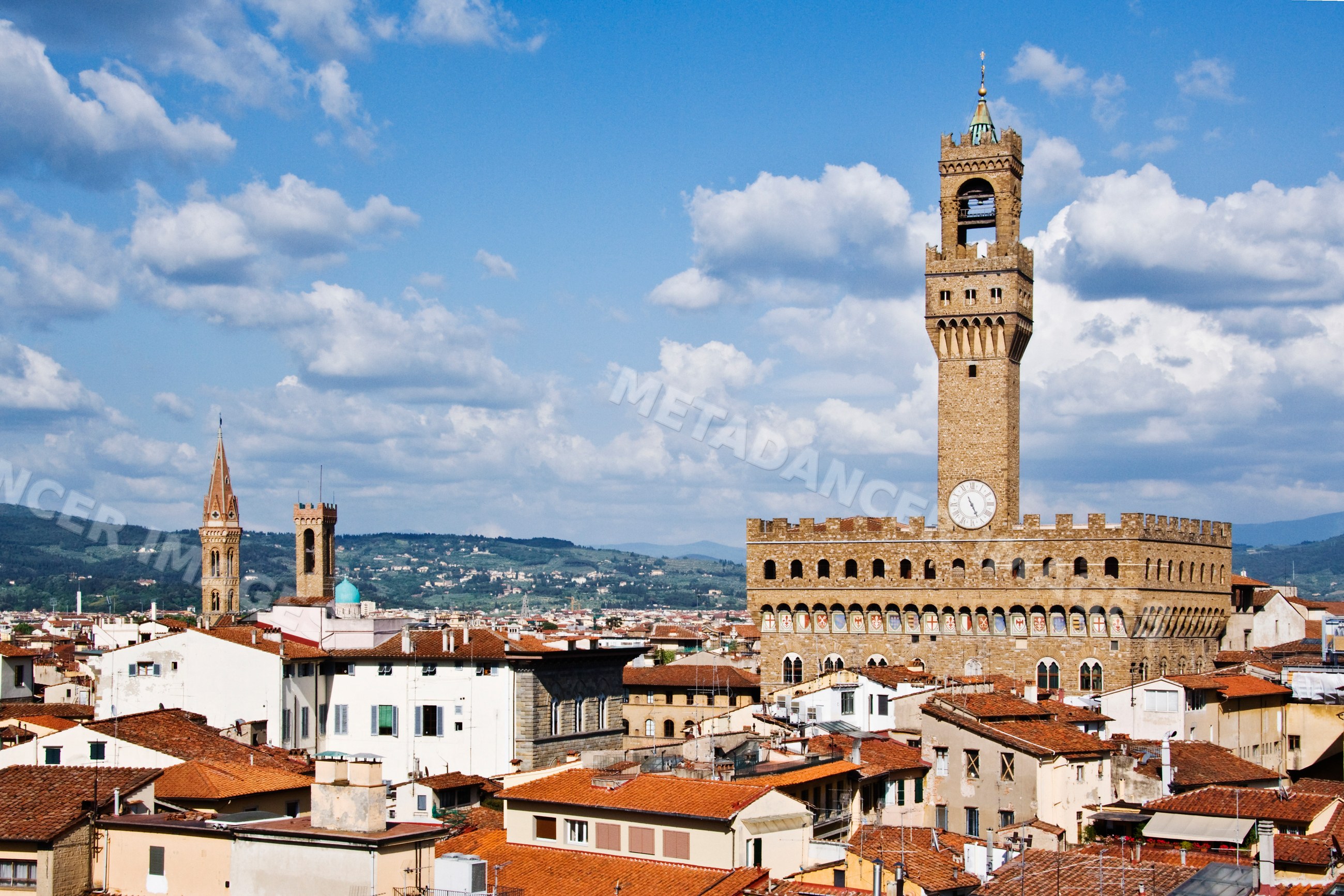 Palazzo vecchio clock tower overlooking florence rooftops with tuscan