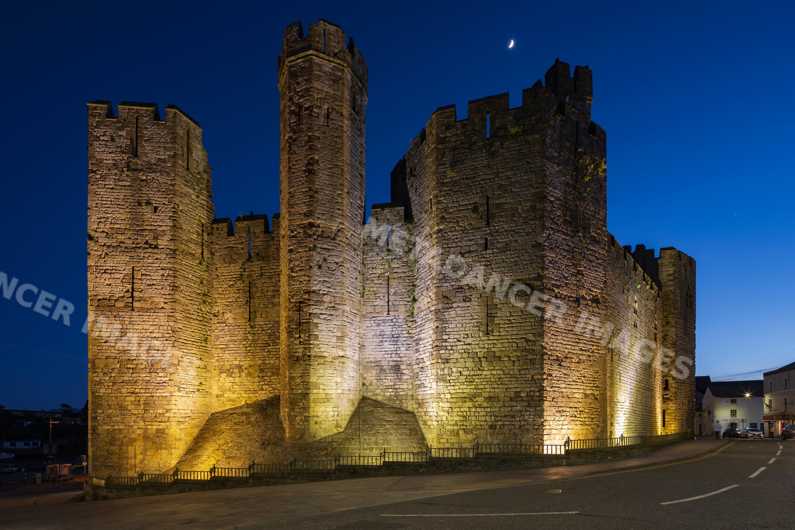 Caernarfon castle stone walls lit at dusk in gwynedd, Wales