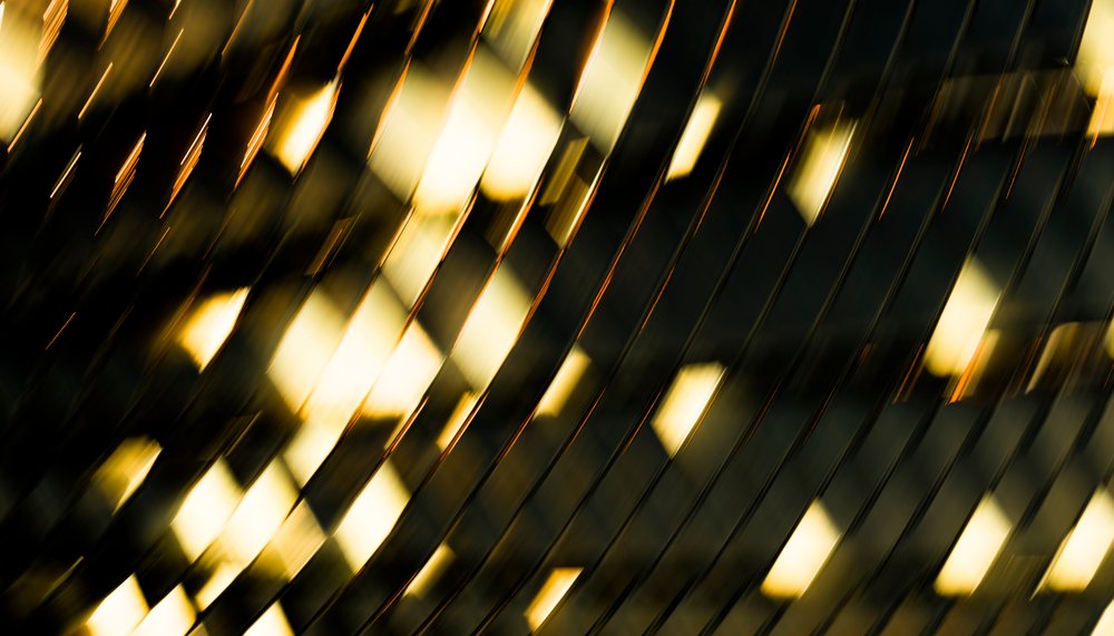 Abstract reflective metal surface with golden light and diagonal
