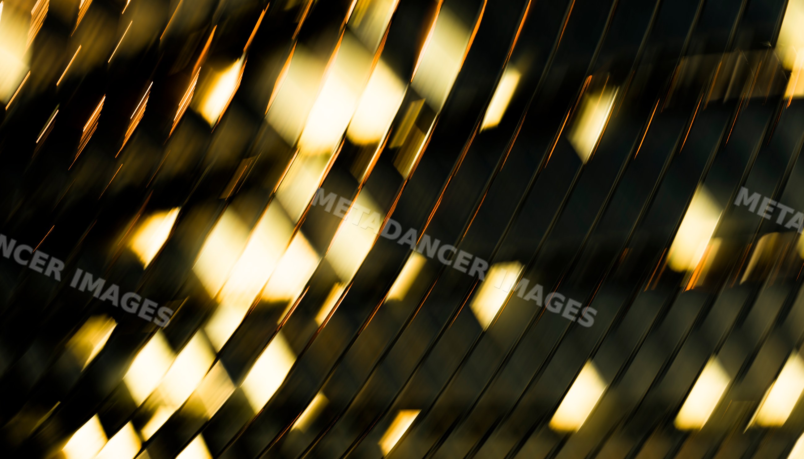 Abstract reflective metal surface with golden light and diagonal