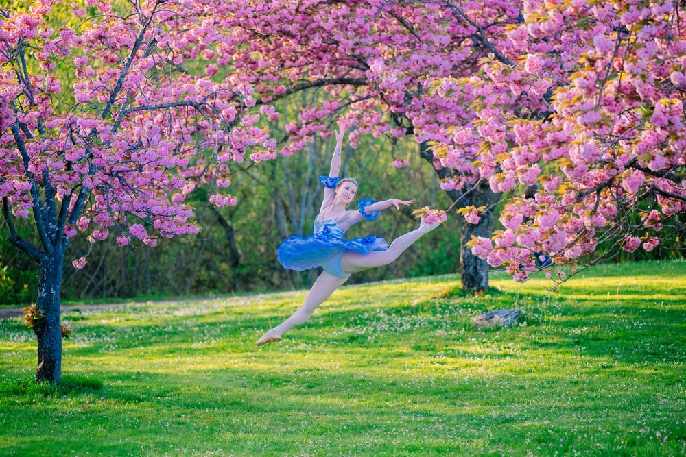 A ballerina leaps gracefully outdoors