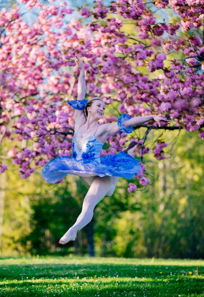 Ballerina leaps gracefully outdoors