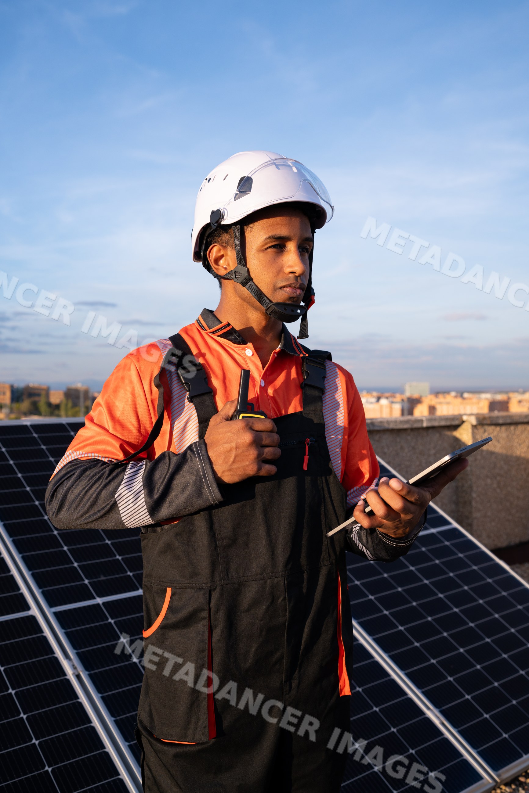 Solar energy technician inspecting solar panels on rooftop in Madrid
