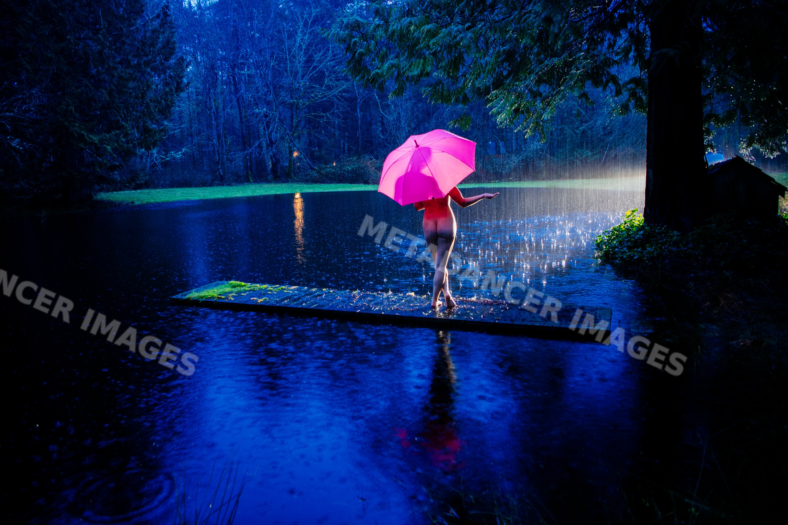Naked white person with pink umbrella on wooden dock