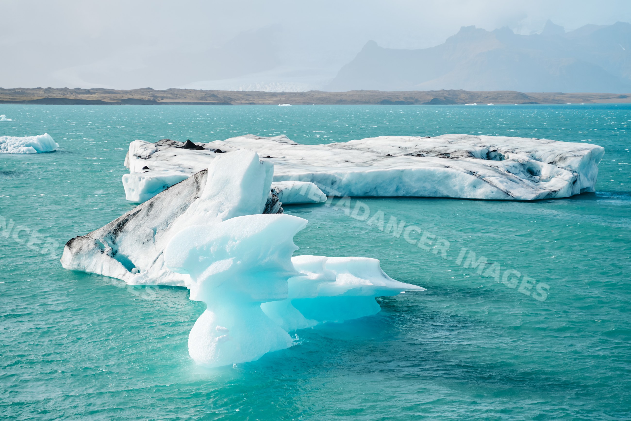 Large icebergs float in a turquoise glacial lake