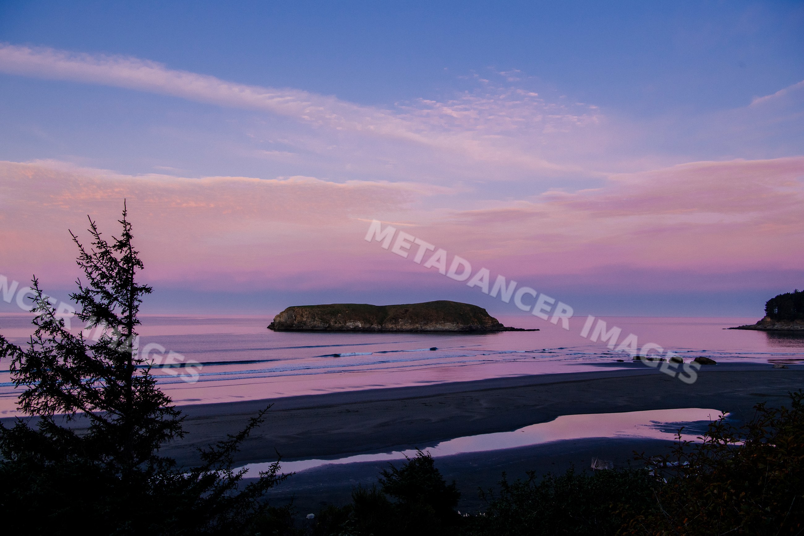 Coastal island at sunset with ocean waves and sandy beach in Oregon