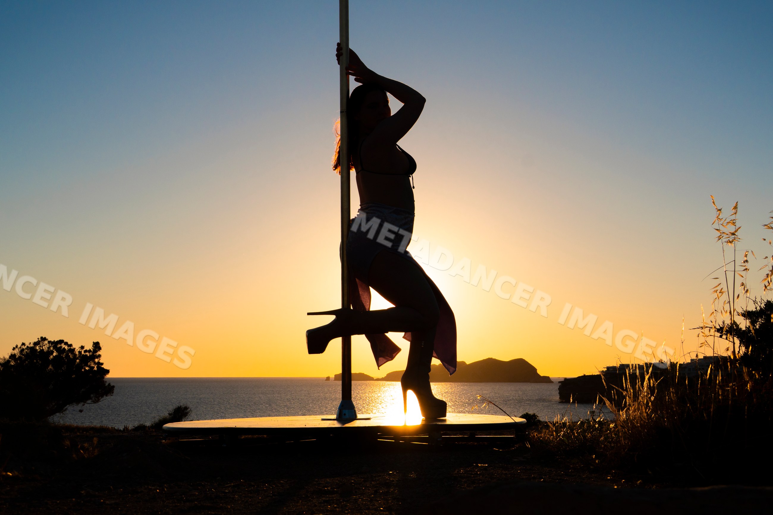 Female Pole Dancer silhouette performing in Ibiza sunset