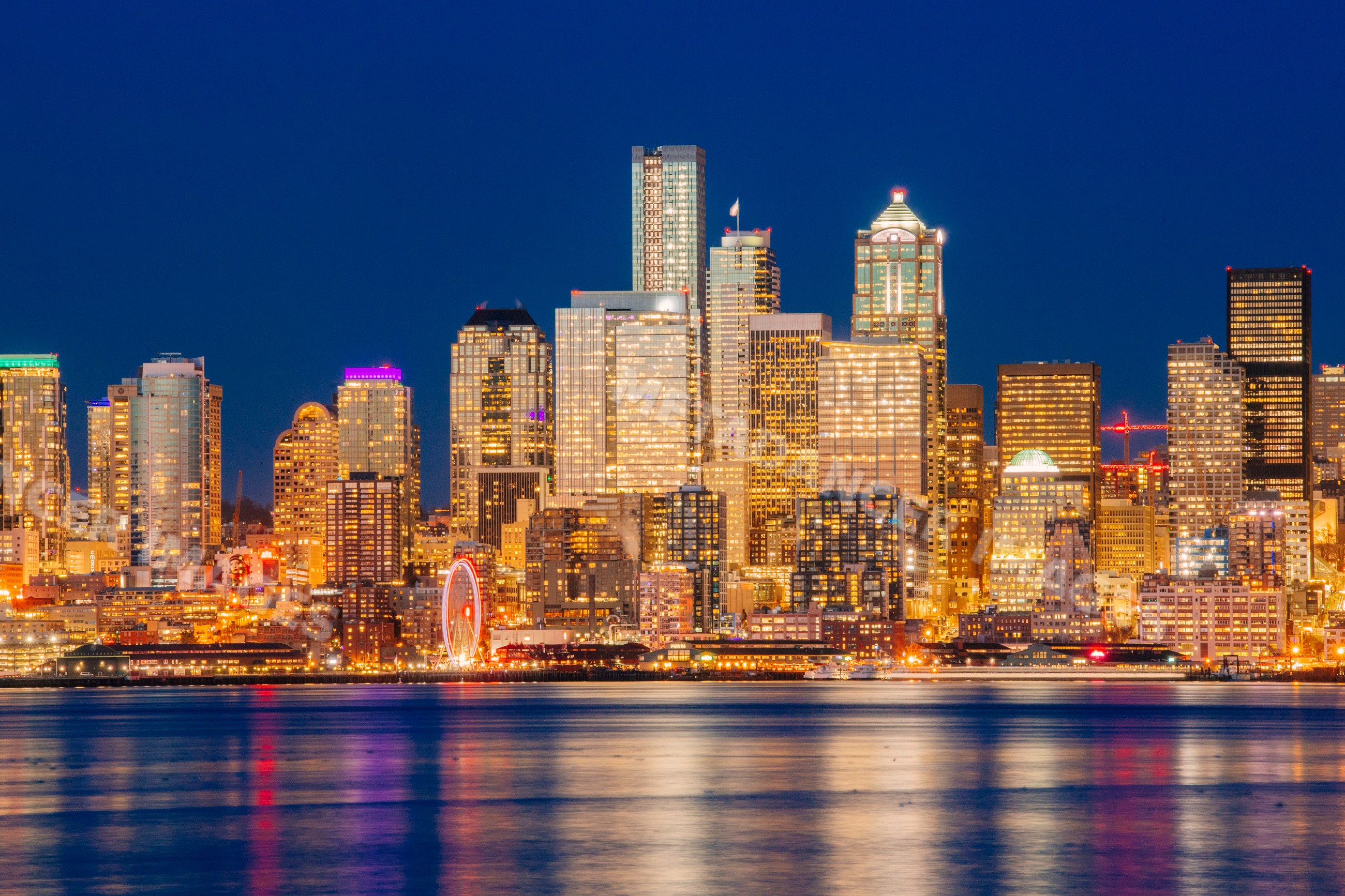 Seattle skyline illuminated at night with water reflections