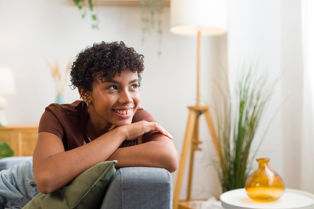 Young African American woman smiling and relaxing on sofa