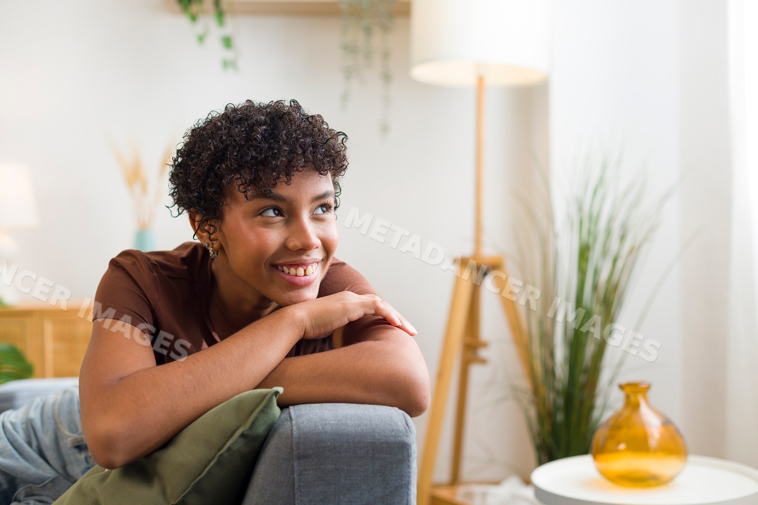 Young African American woman smiling and relaxing on sofa