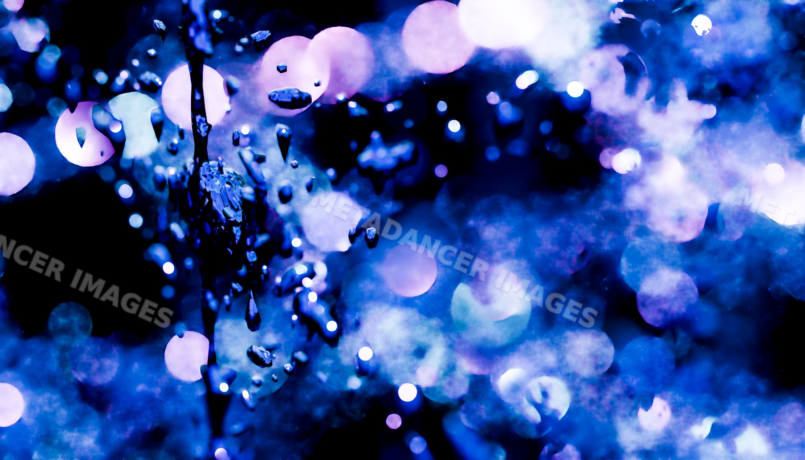 Water droplets splashing with blue and purple bokeh lights
