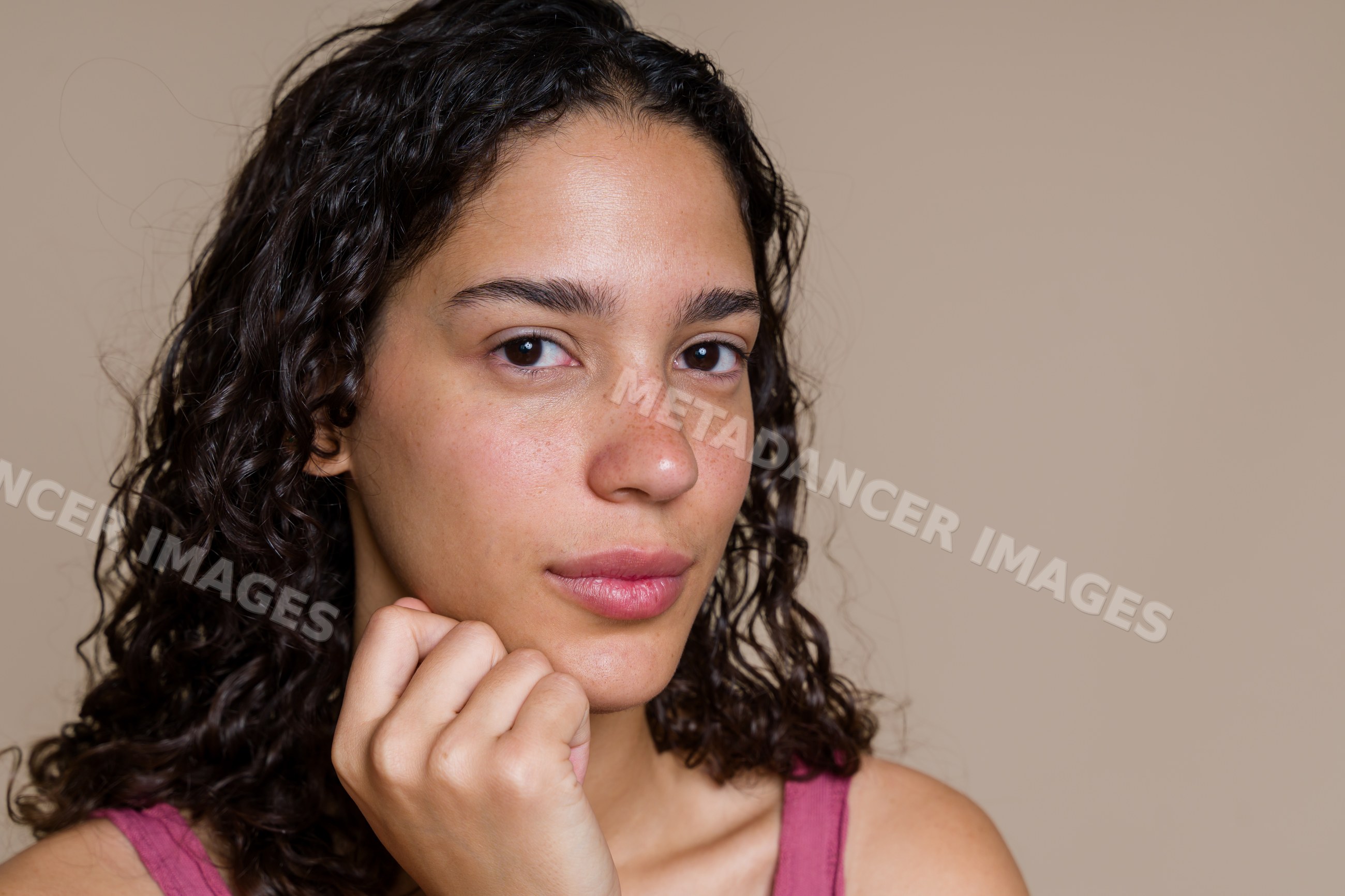 Portrait of a young Hispanic adult woman with curly hair and natural