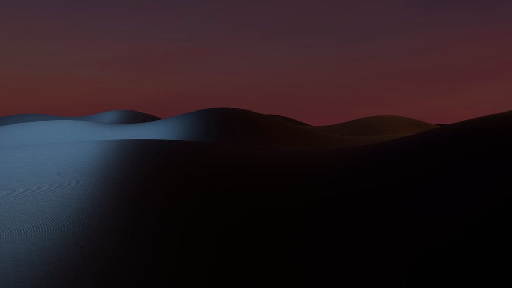 Silhouetted sand dunes under dark evening desert sky at sunset