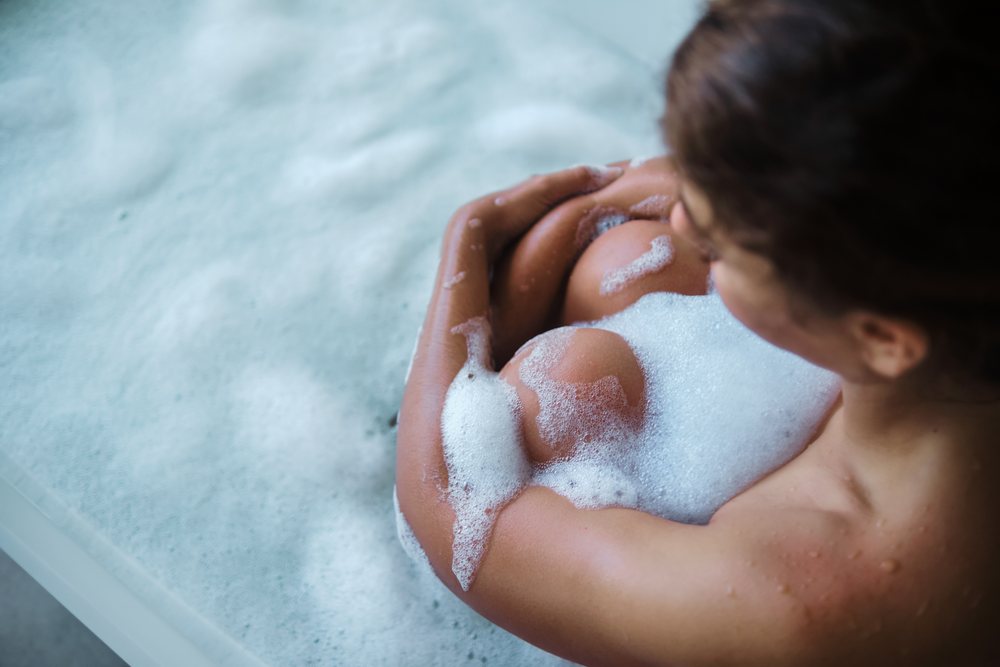 A white woman enjoys a relaxing bubble bath