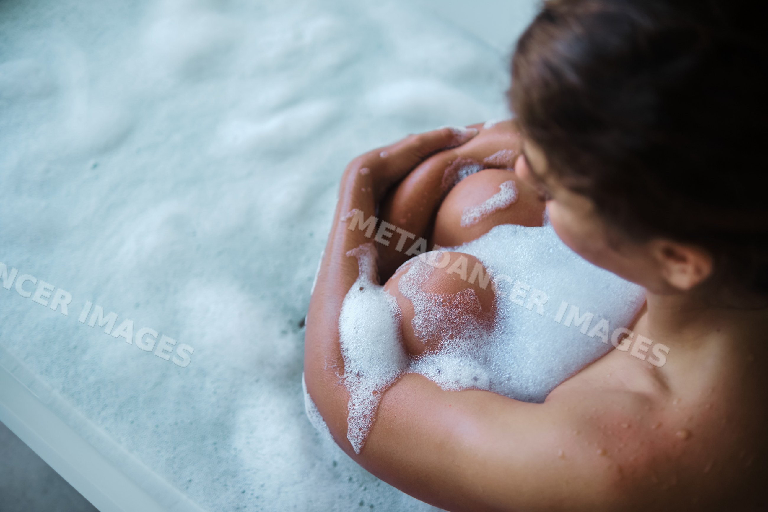 A white woman enjoys a relaxing bubble bath