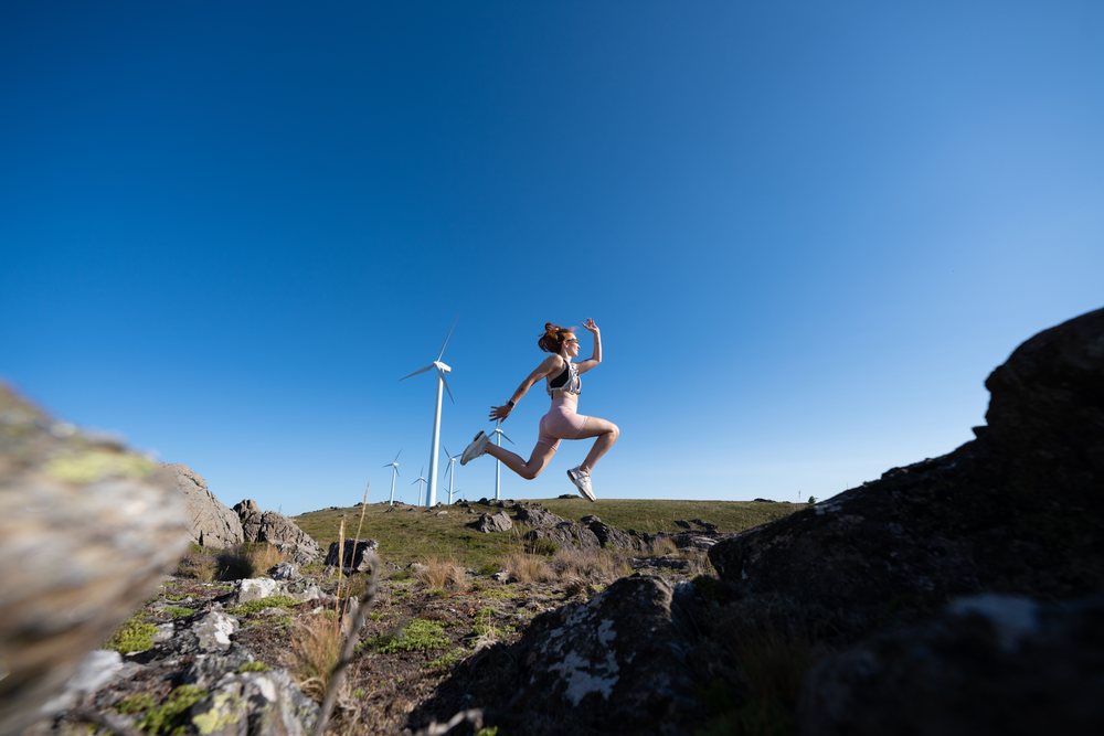 A white woman jumping energetically outdoors