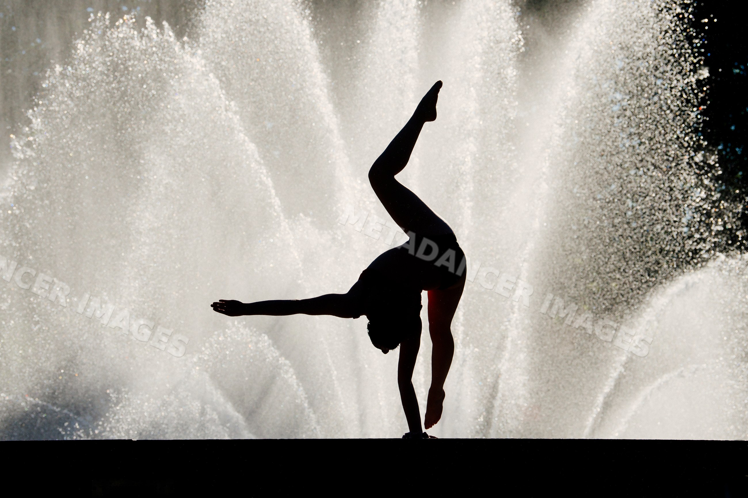 Silhouette of white person doing handstand exercise