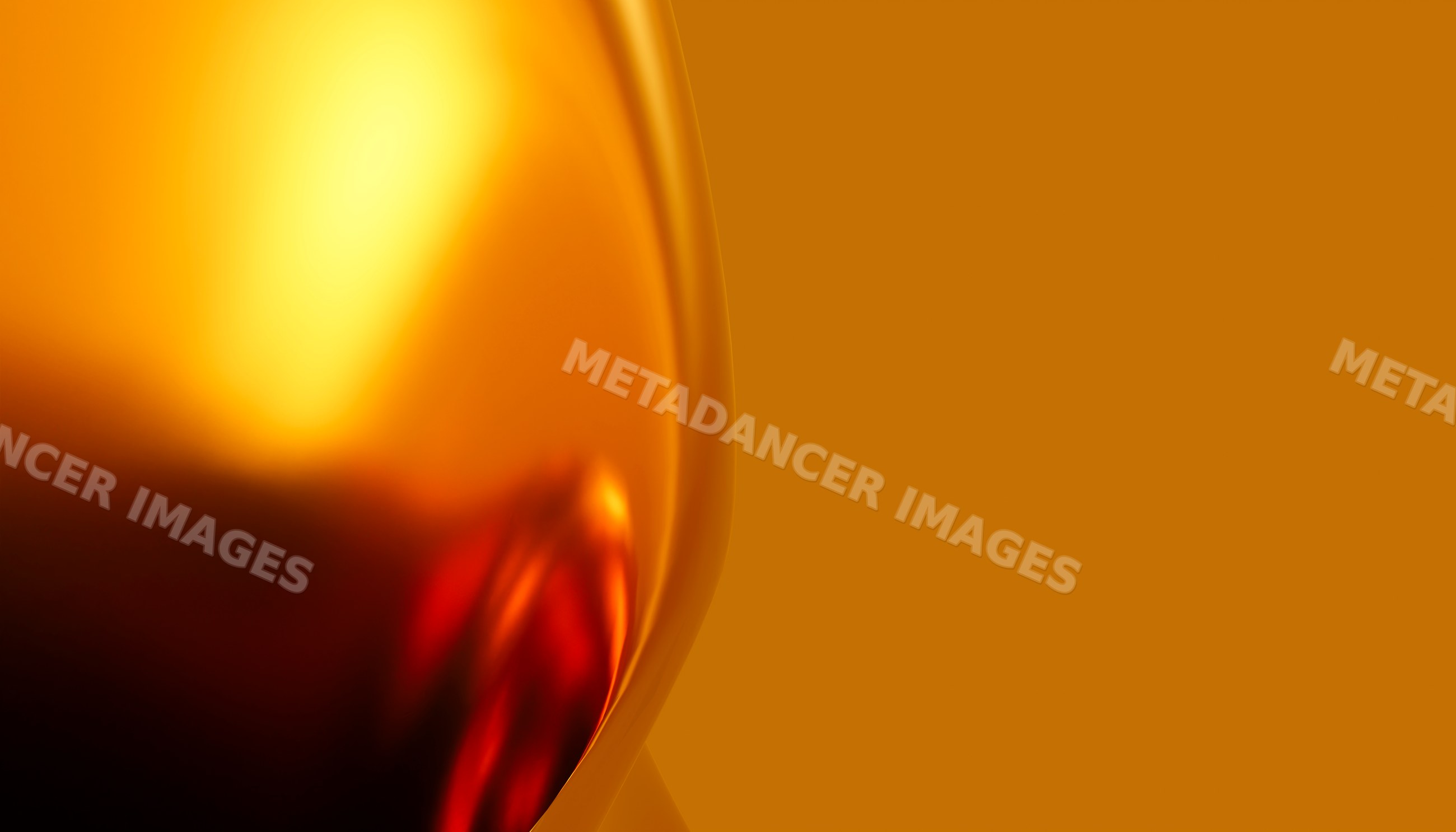 Close-up of red wine in glass with bright orange background