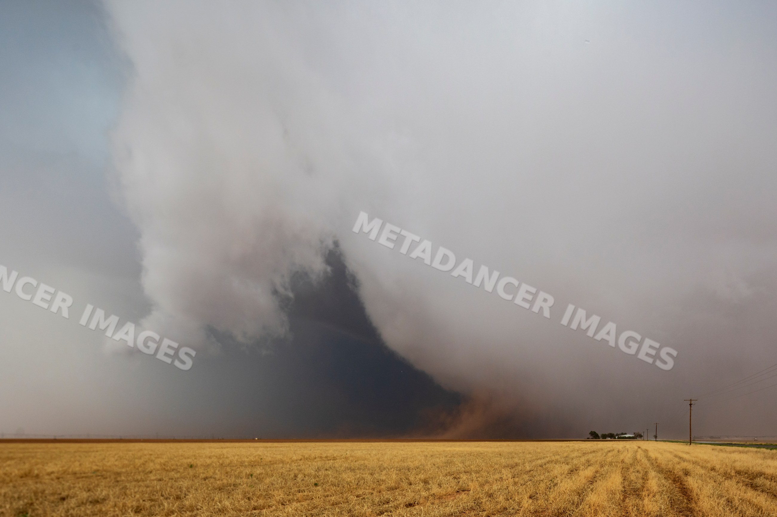 Severe storm cloud with tornado formation over harvested wheat field