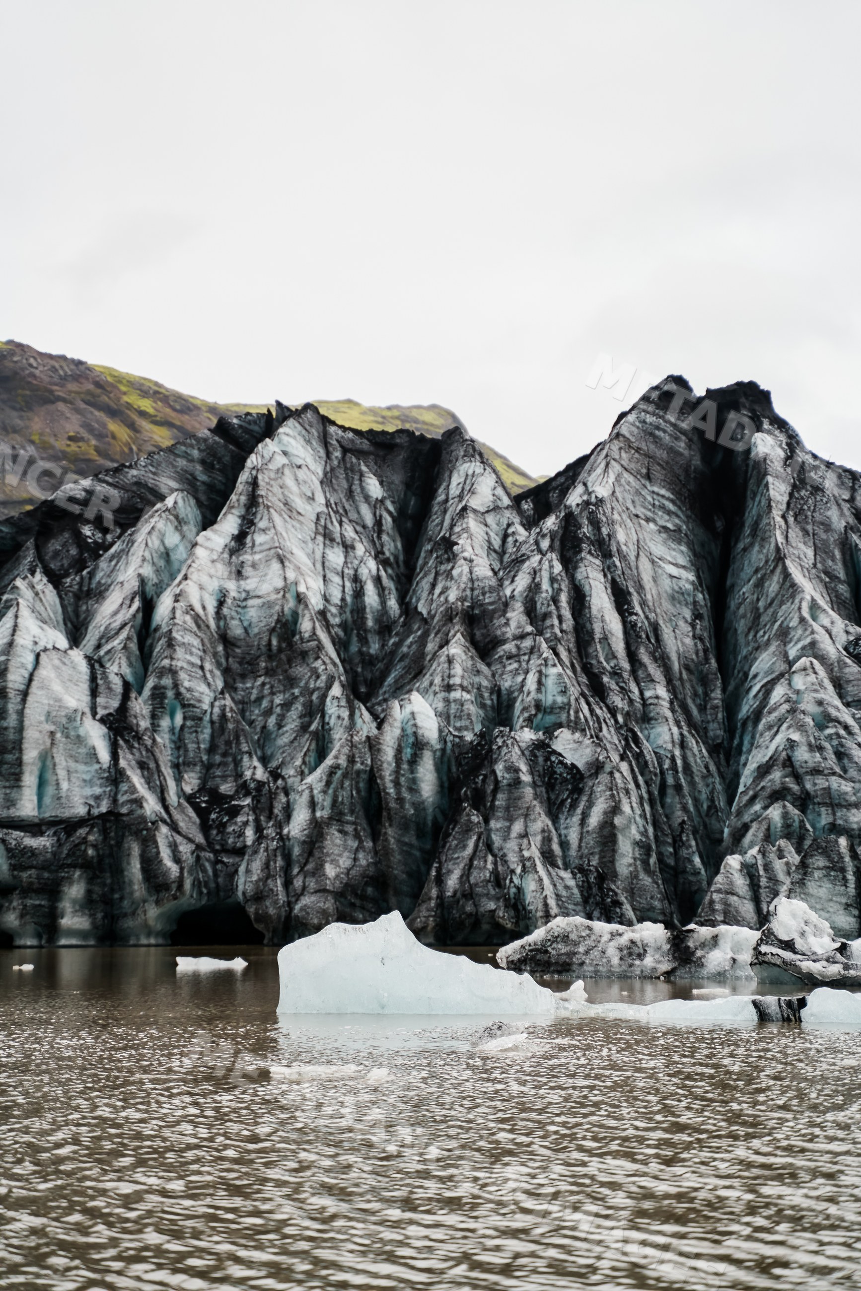 Icy glacier cliffs with floating icebergs in a glacial lagoon