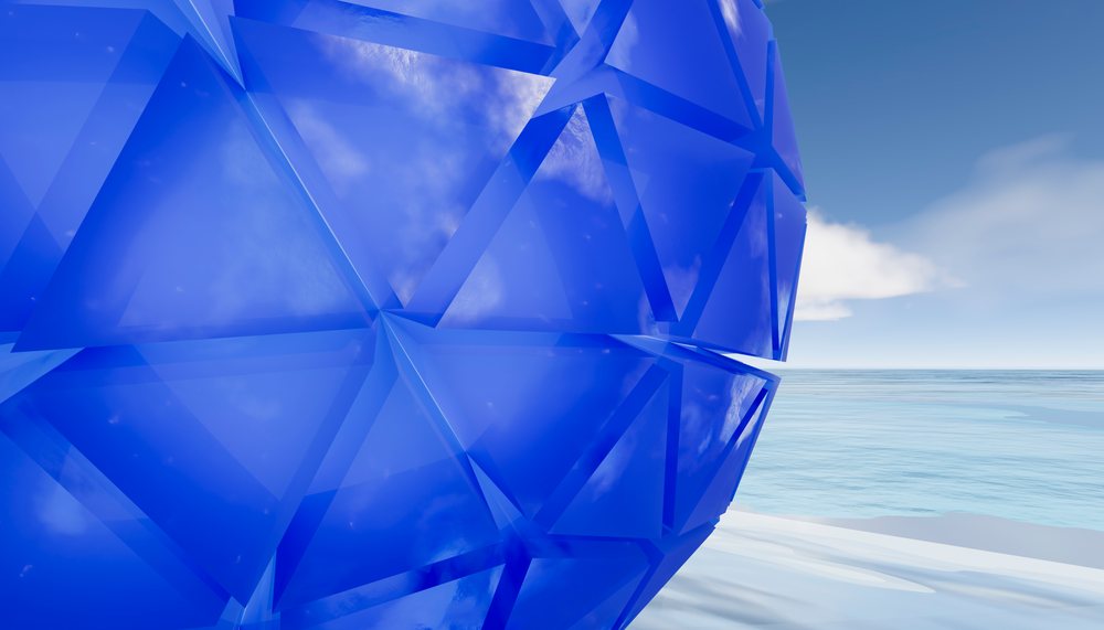 Blue geometric glass sphere with triangular facets by calm ocean
