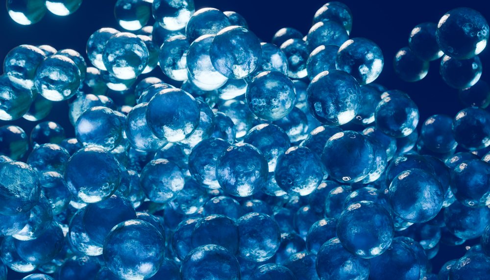Macro close-up of floating blue translucent gel spheres