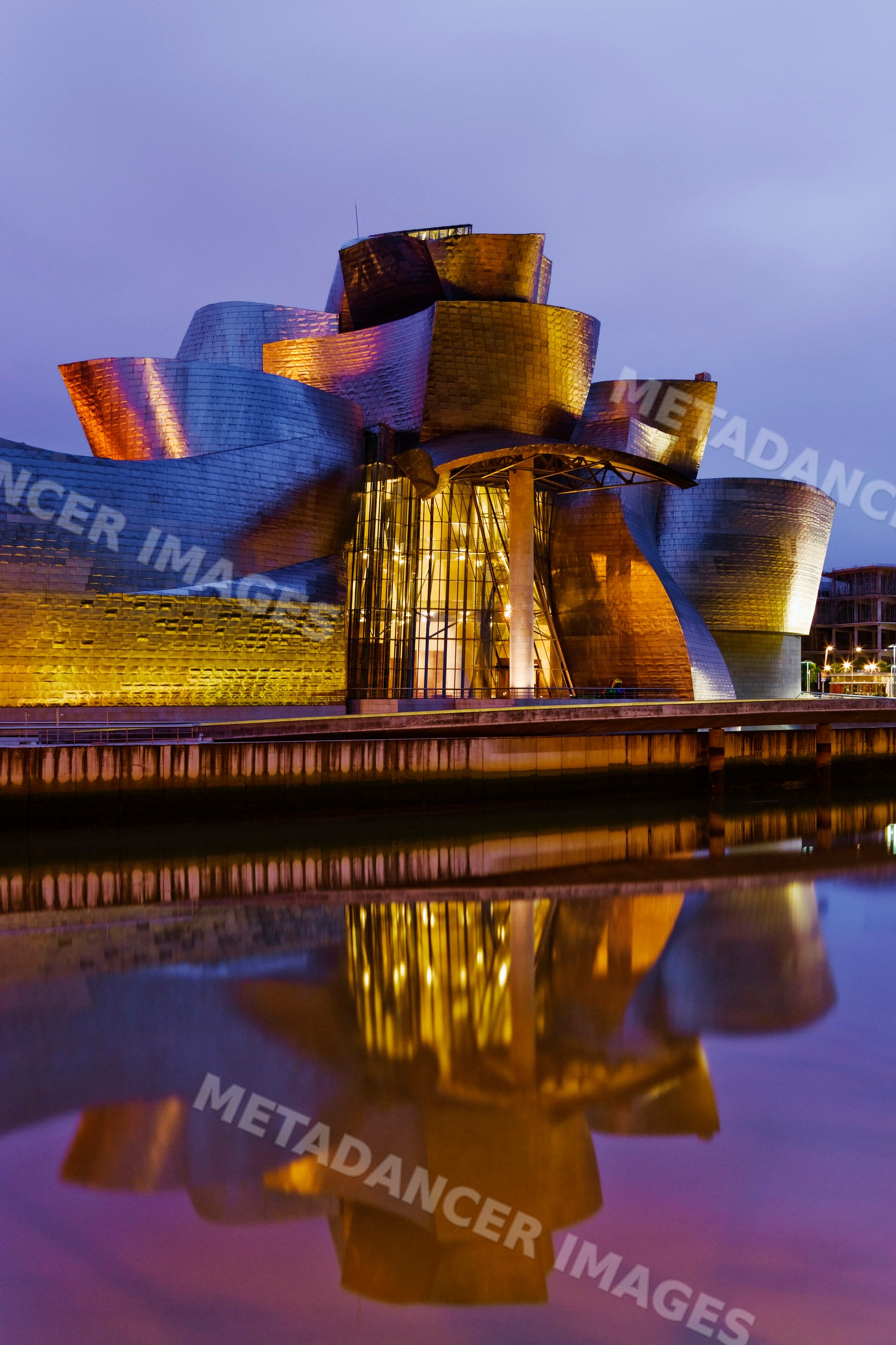 Guggenheim museum illuminated in the evening with water reflection