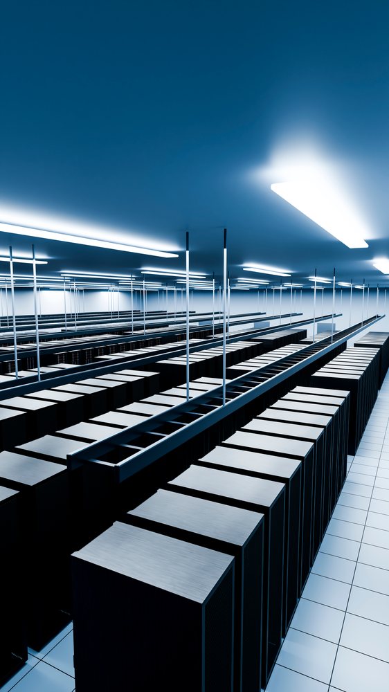 Data center with rows of server racks under blue lighting