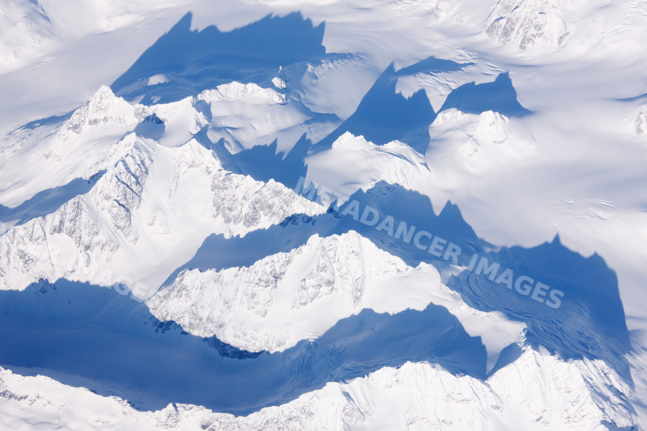 Snow-covered mountain peaks casting shadows