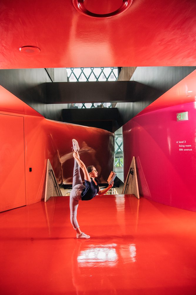 A woman reads a book practicing yoga in Seattle public library hallway