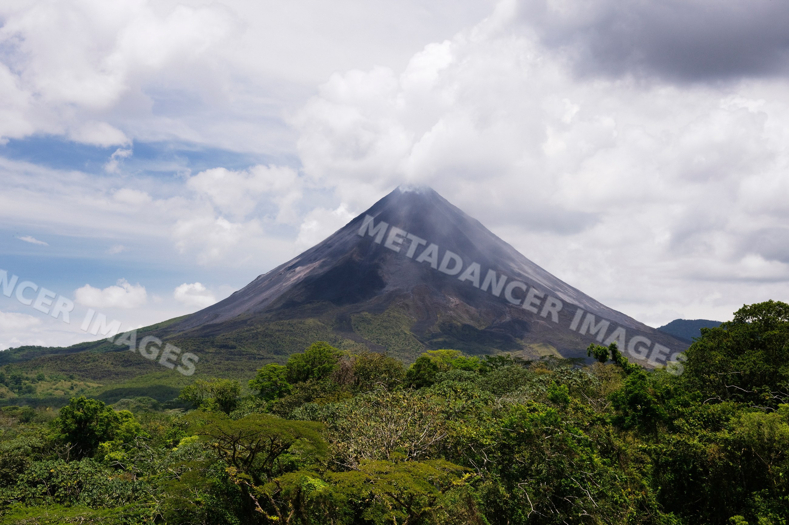 Arenal volcano rising above tropical forest in costa rica