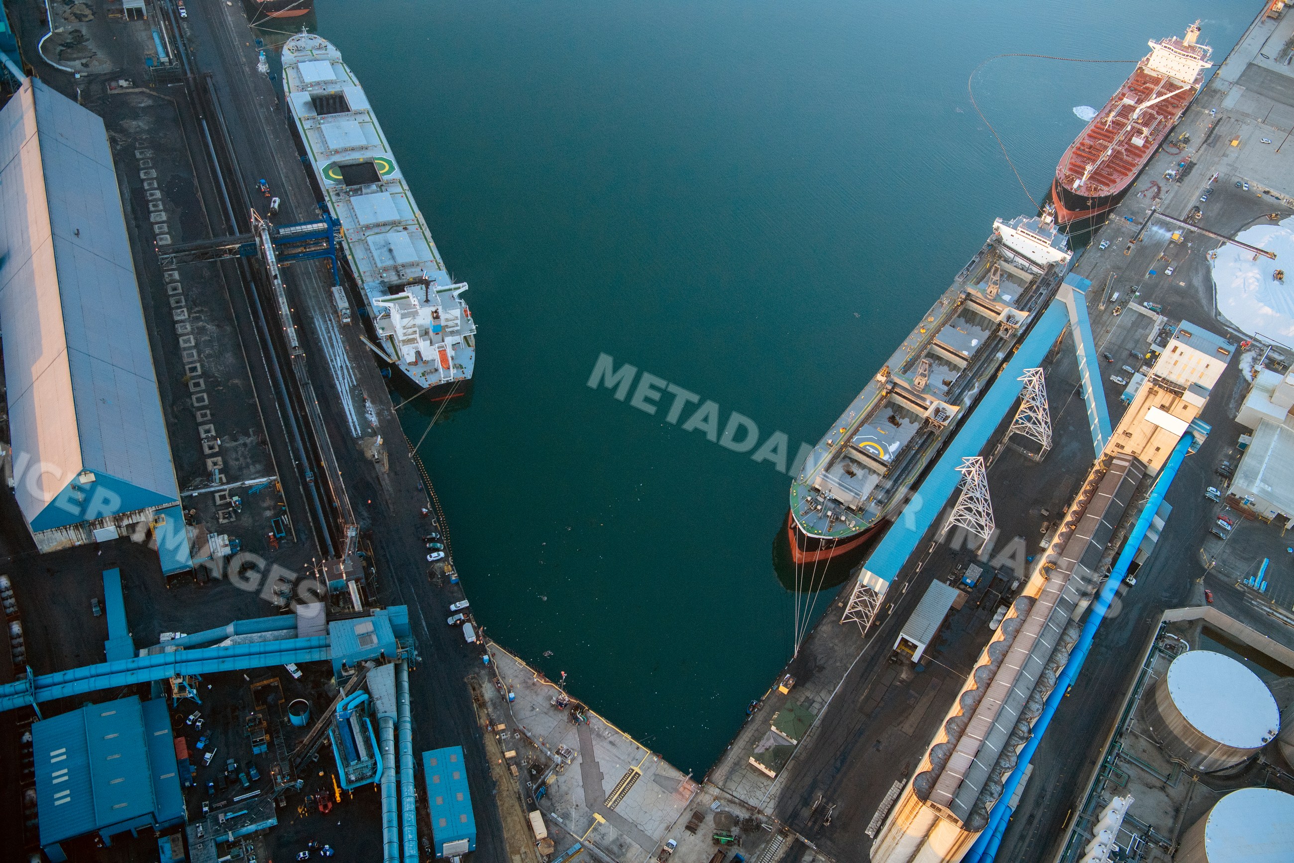 Cargo ships docked at an industrial shipping terminal in a beach