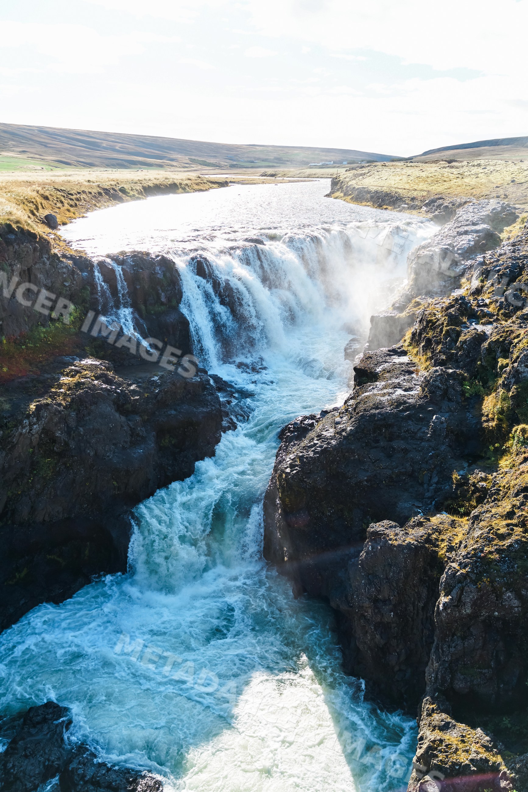 Waterfall cascading over rocky cliffs with flowing river