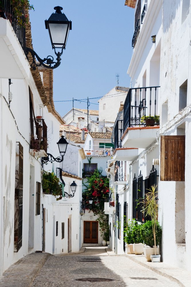 Narrow street with white mediterranean-style buildings, Spain