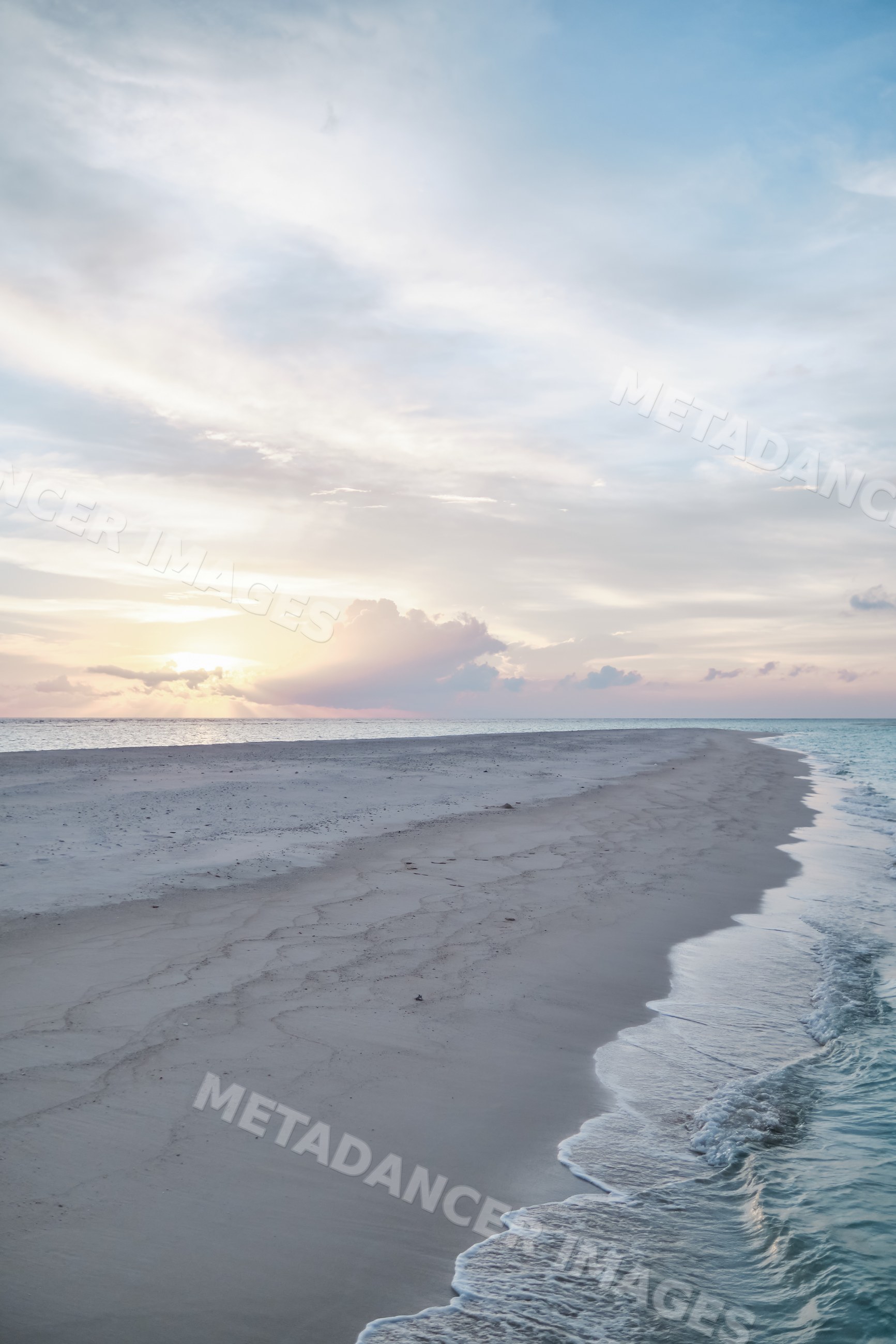 A tranquil beach shoreline at sunset in the Maldives