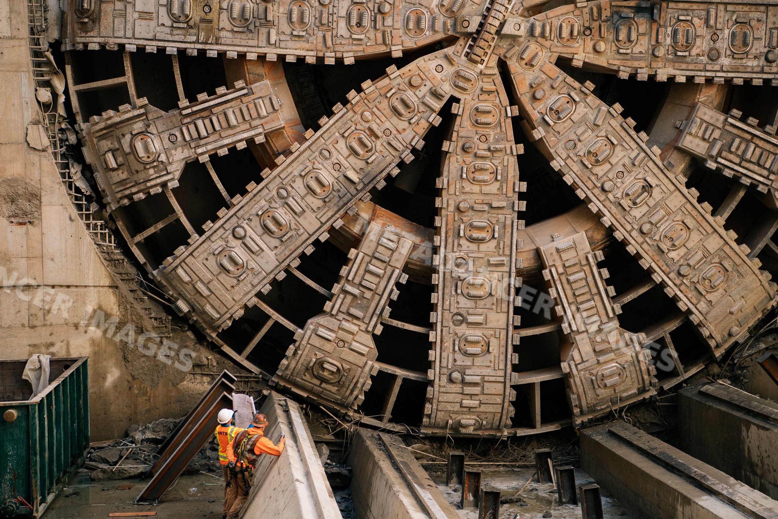 Construction white workers inspect plans by tunnel boring machine