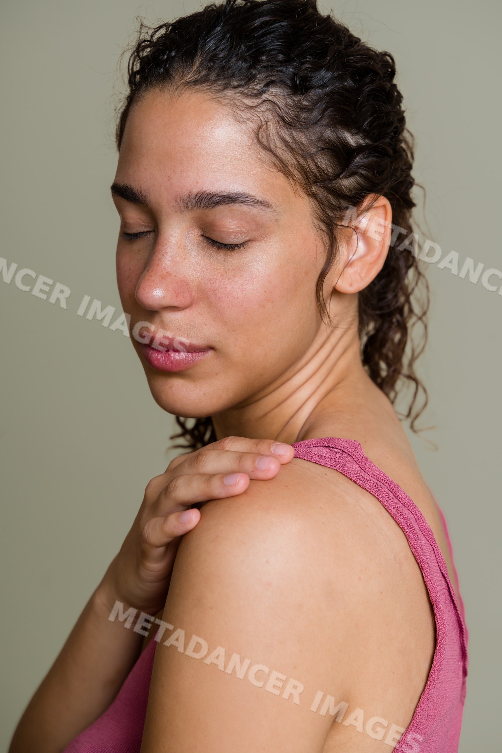 Hispanic woman gently touching shoulder in serene studio portrait
