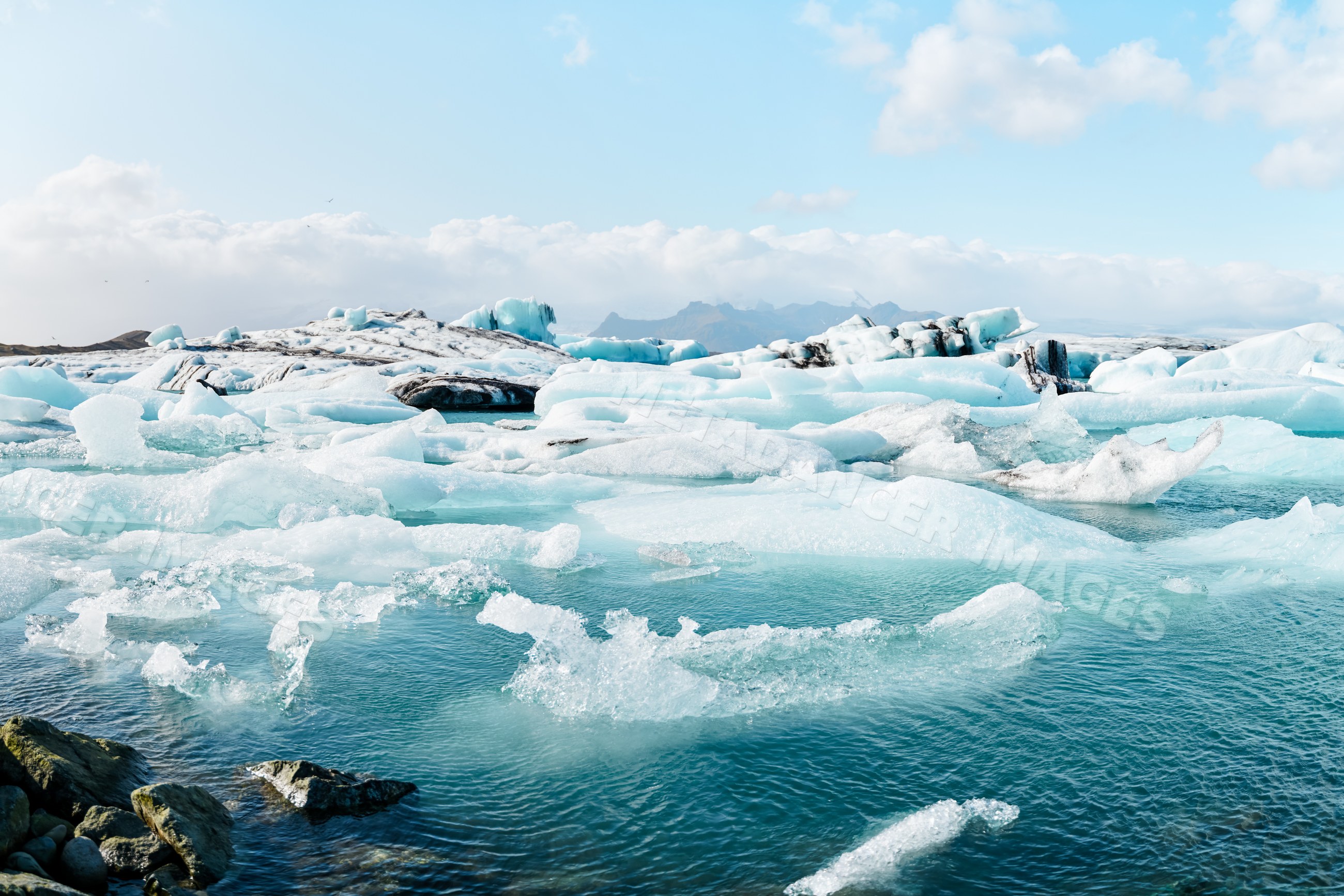 Floating icebergs and glacier fragments fill a glacial lagoon