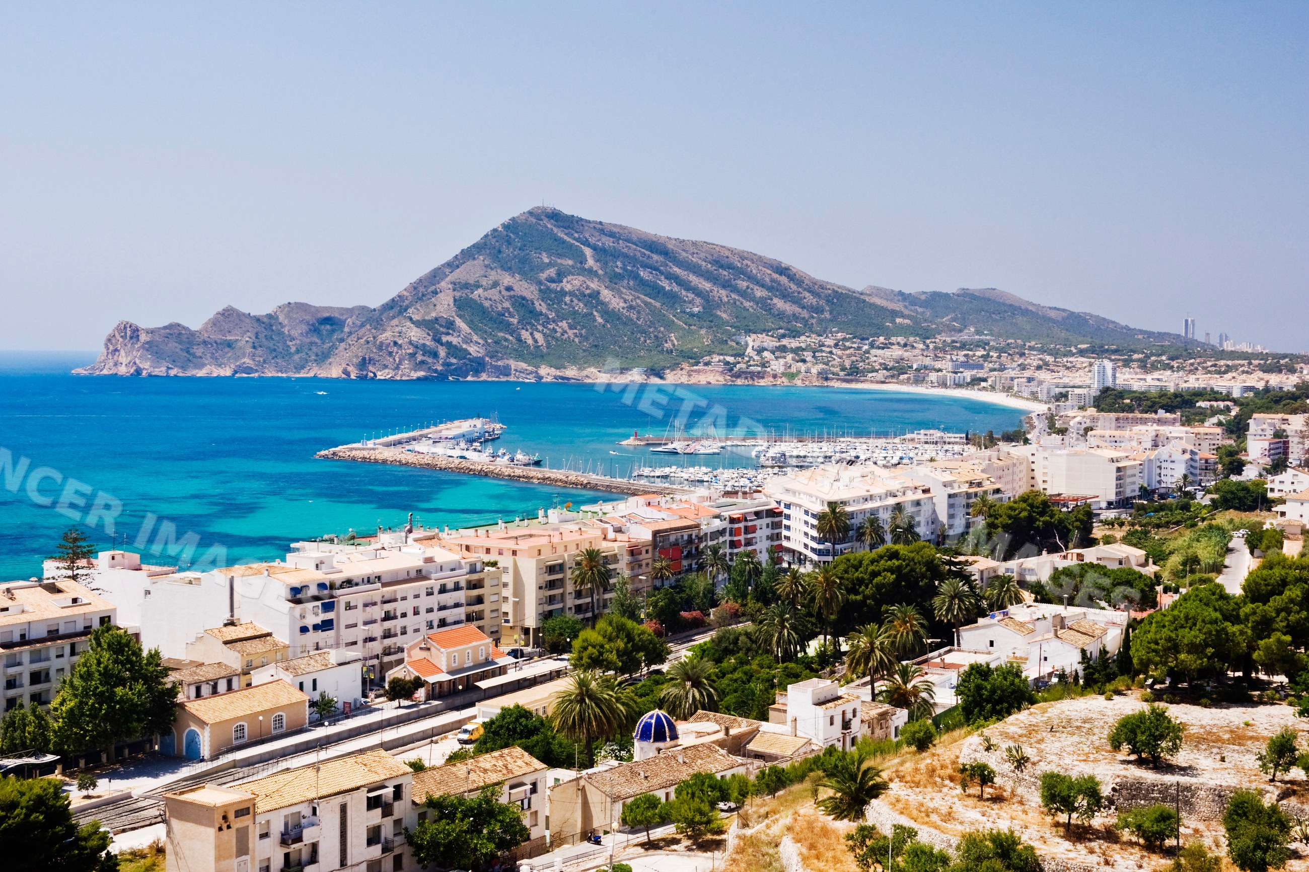 Mediterranean coastal town with marina and mountain Spain