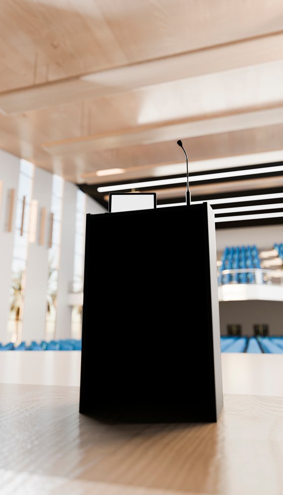 Podium with microphone and monitor in empty lecture hall