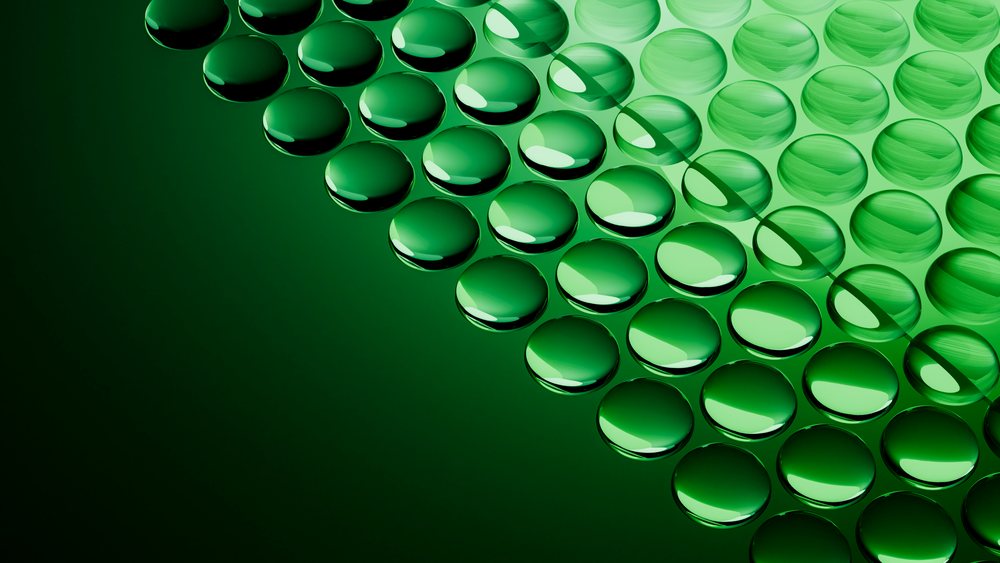 Green water droplets clustered on reflective surface