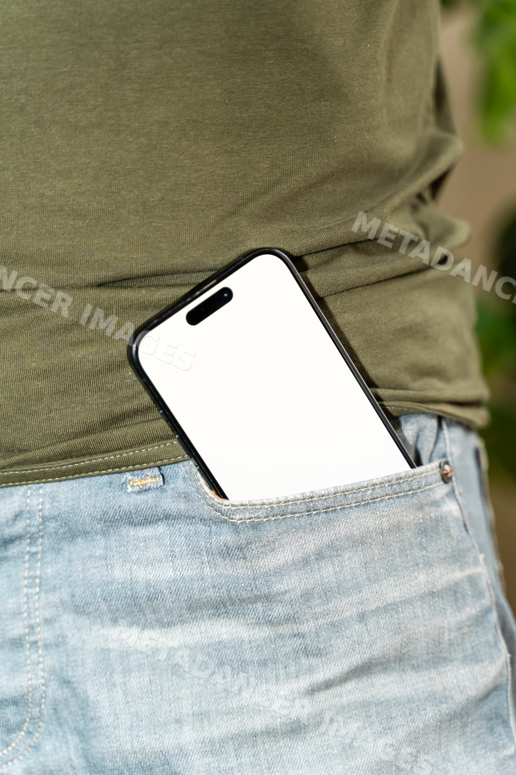 Smartphone in jeans pocket with white person wearing green shirt
