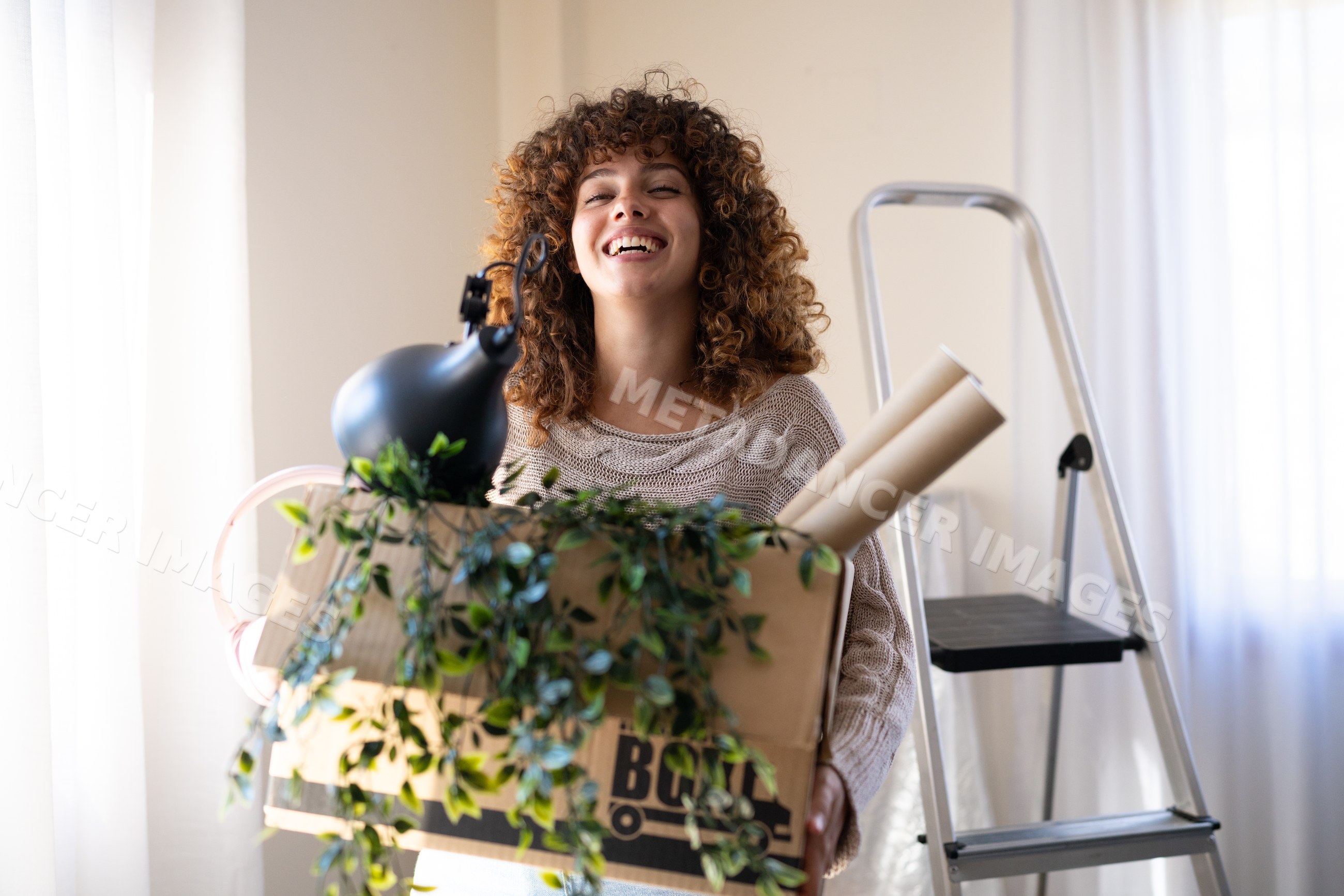 White woman carrying box with household items