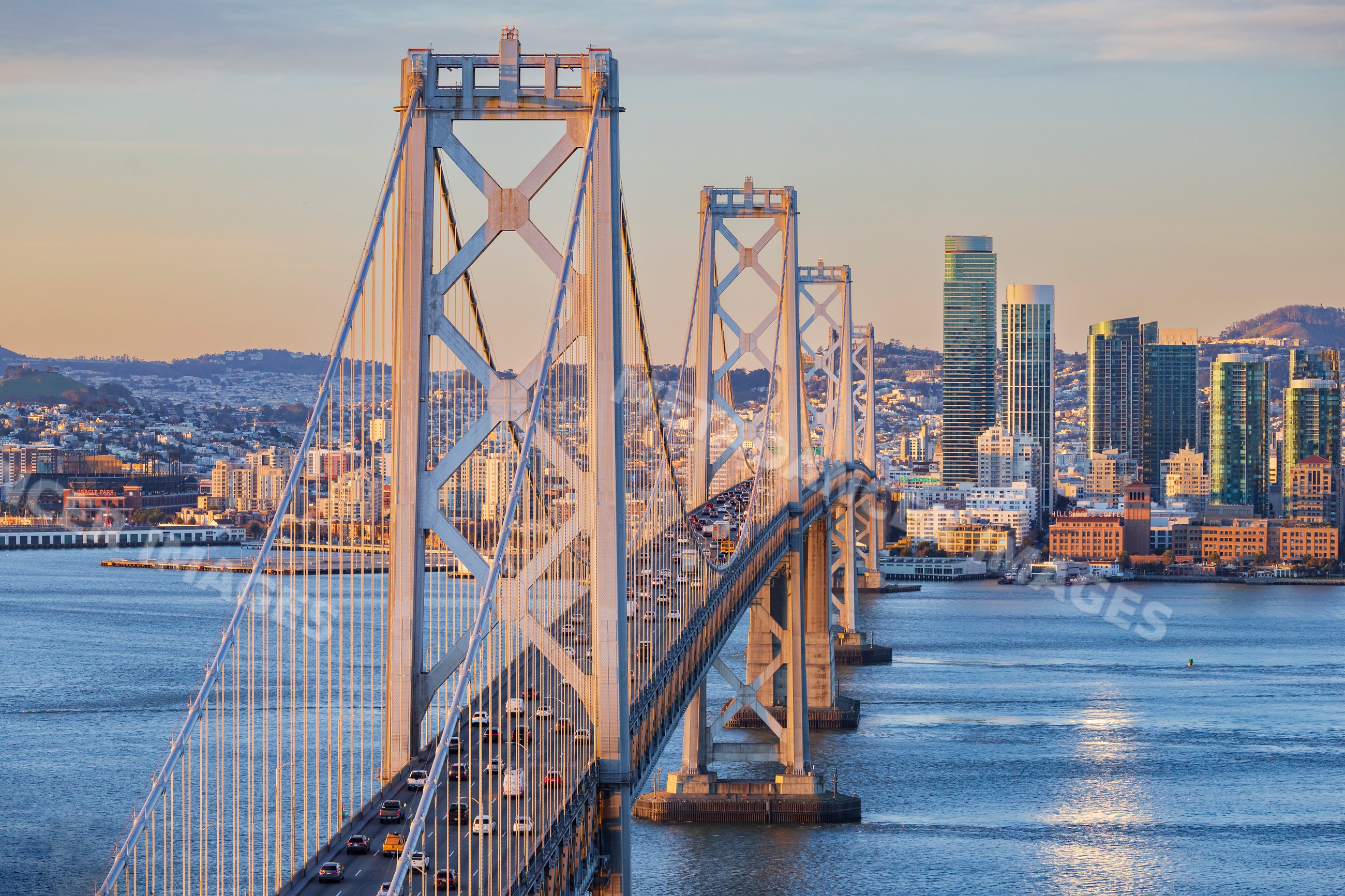 Traffic crossing San Francisco bay Bridge at Sunrise with city skyline